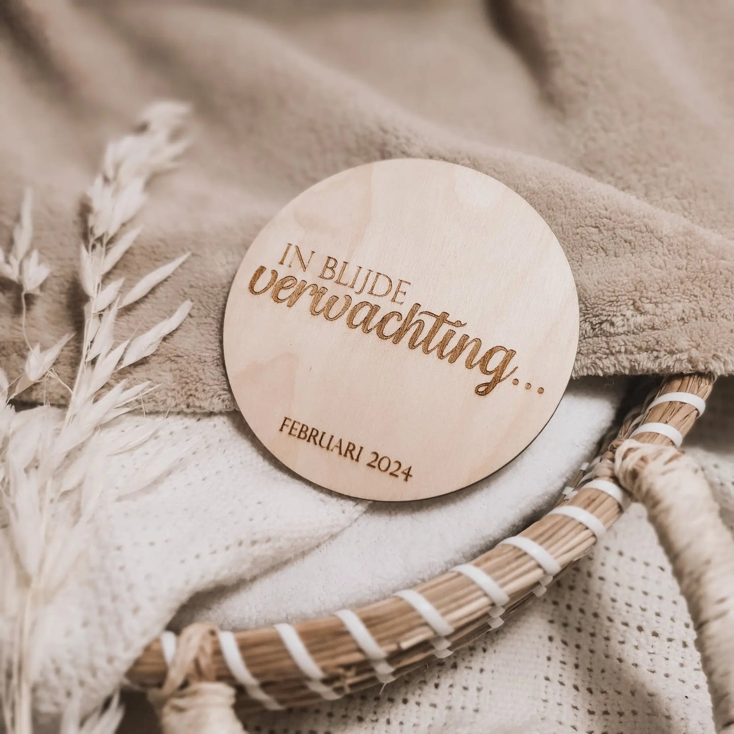 Houten aankondigingsbordje voor een zwangerschap, gegraveerd met de tekst "In blijde verwachting" en de uitgerekende datum.