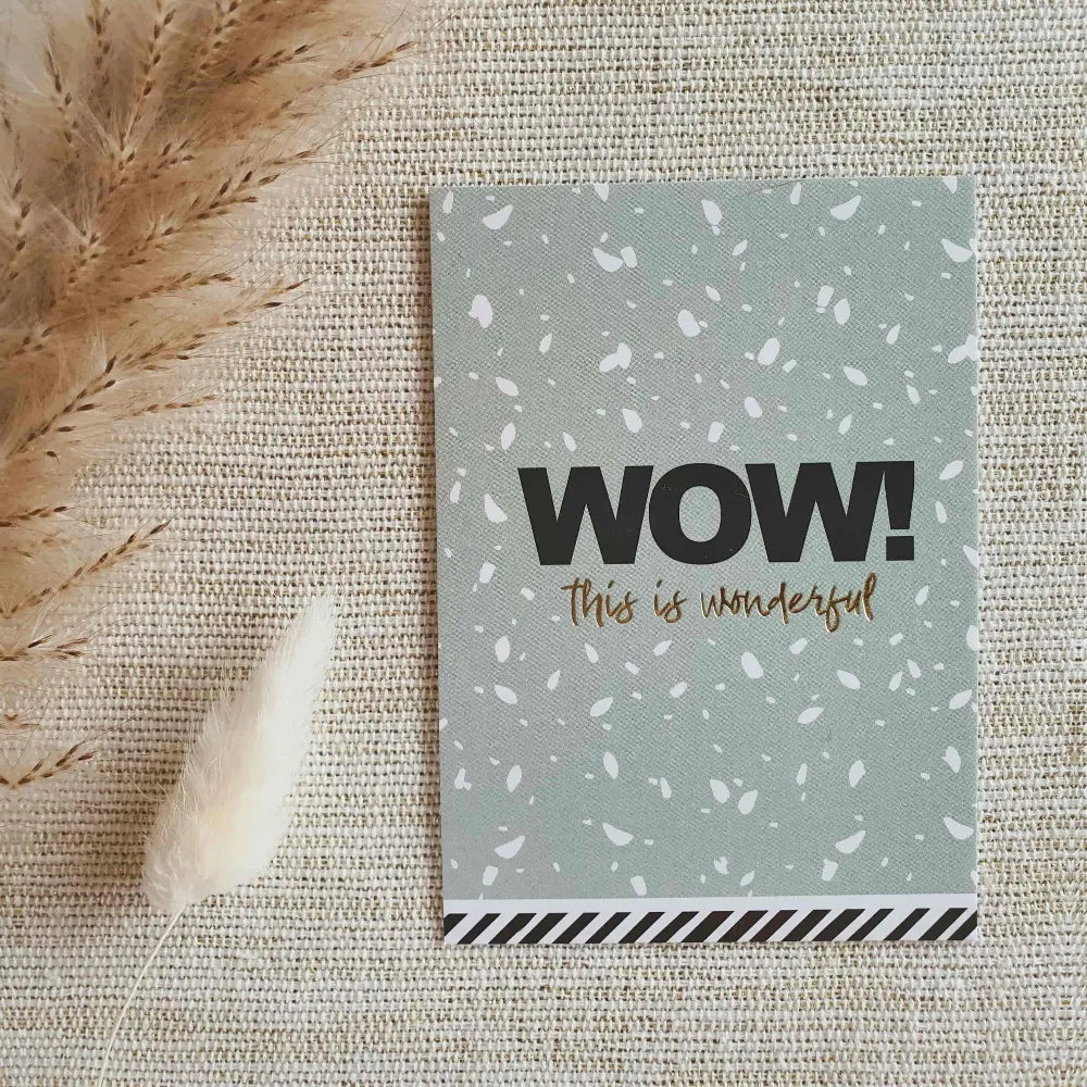 Blauw kaartje met confetti en de tekst 'WOW! This is wonderful' in zwart, wit en gouden opdruk.