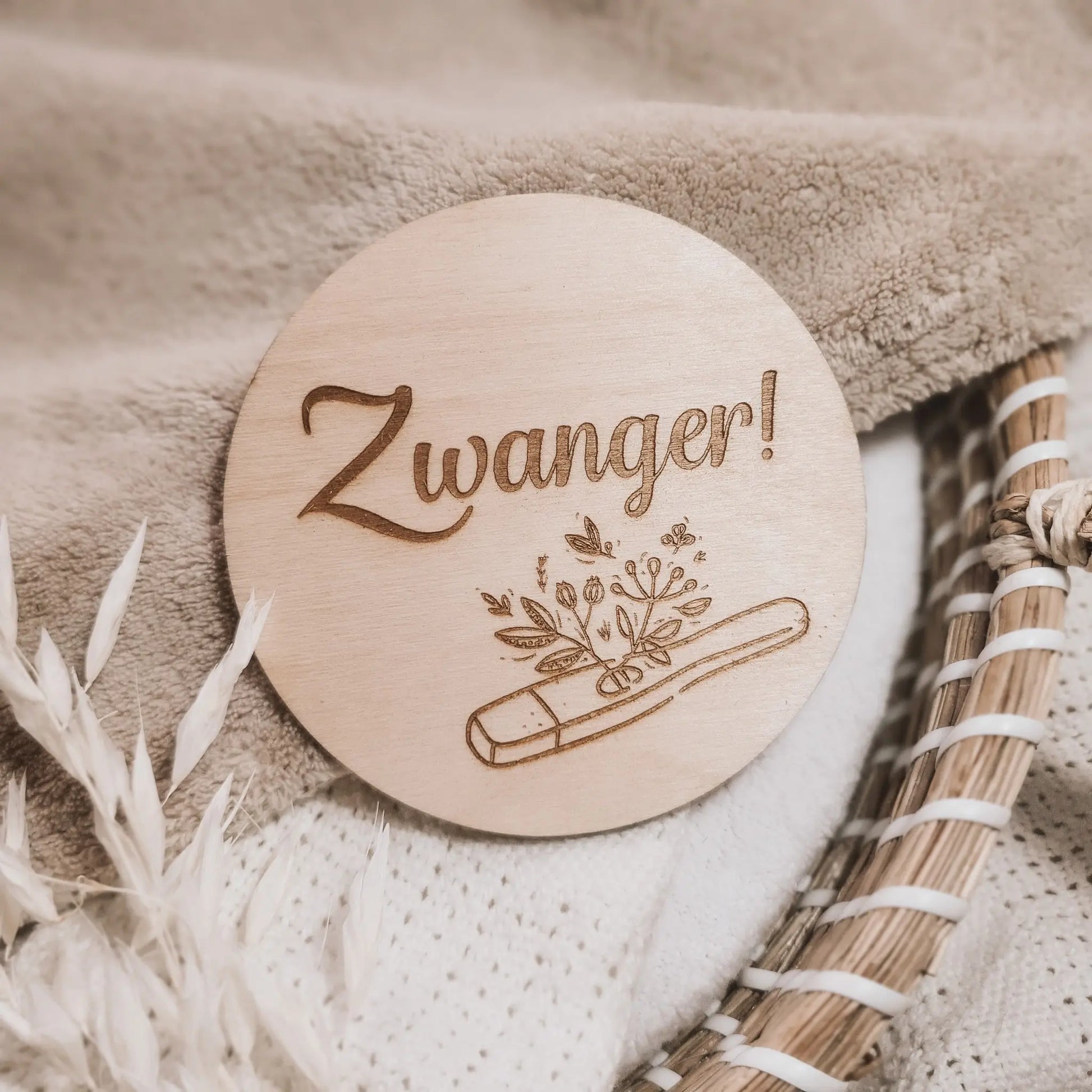 Houten aankondigingsbordje voor een zwangerschap, gegraveerd met de tekst "zwanger" en een zwangerschapstest waar plantjes uit groeien.