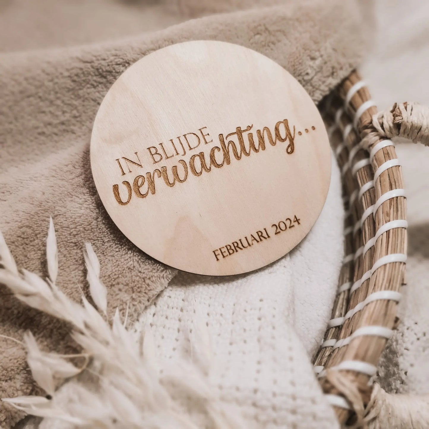 Houten aankondigingsbordje voor een zwangerschap, gegraveerd met de tekst "In blijde verwachting" en de uitgerekende datum.